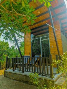 Una casa con un porche con dos sillas. en Southern Edge Cabanas, en Tangalle