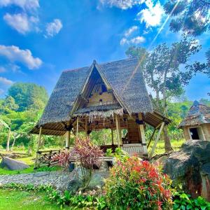 a house with a thatched roof in a garden at Resort Saung Pakis Bogor in Bogor +18 photos