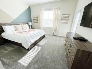 a bedroom with a bed and a dresser and a television at Luxury 2bd 2 bath Condo Home 232 in Davenport