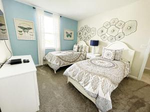 a bedroom with two beds and a table and a window at Luxury 2bd 2 bath Condo Home 232 in Davenport +71 photos