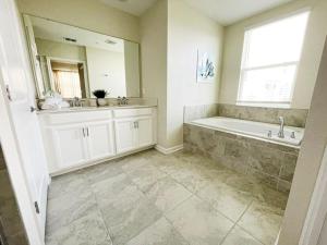 a bathroom with a tub and a sink and a mirror at Luxury 2bd 2 bath Condo Home 232 in Davenport