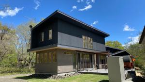 una casa con una casa nera e grigia di Tabinoteitaku Miyagi Zao a Zao