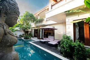 a villa with a swimming pool and a building at Villa Tepi Sungai - Luxury 6-BR villa, sleeps 14, 15m pool in Seminyak in Legian