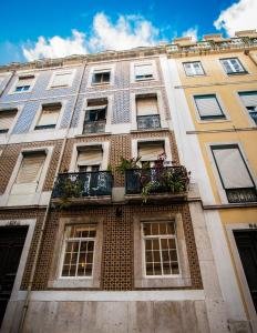 a tall building with a balcony with plants on it at Entre o Carmo e a Trindade in Lisbon