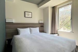 A bed or beds in a room at Odysis Sapporo Odori Koen Hotel
