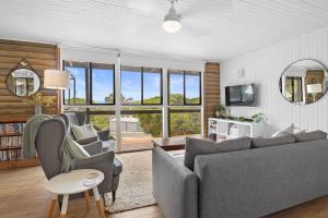 a living room with a couch and chairs and windows at The Log Cabin - 2 Scenic View Drive, Second Valley in Second Valley