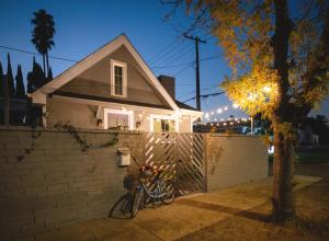 a white house with a fence and a bike at Hollywood Family Nest in Burbank, Steps to Studios! in Burbank