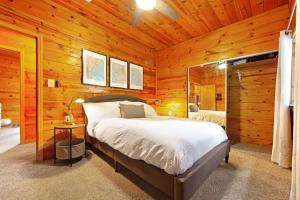 a bedroom with a bed in a wooden cabin at Charming 3BR with Hot Tub Balcony & Wood Stove in Guerneville