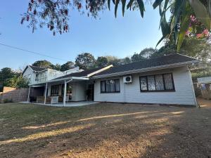 a white house with a yard in front of it at The Aurum guesthouse in Durban