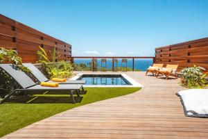 a backyard with a swimming pool and a deck at Villa Bo'M Bleue in Petite Île