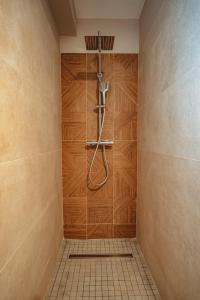 a bathroom with a shower with a wooden wall at Villa Bo'M Bleue in Petite Île +15 photos