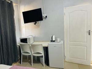 a room with a desk with a computer and a tv at Legugu Bed and Breakfast in Nongoma