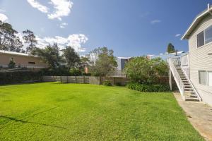 Un patio con una cerca y una casa en Surf & Turf Retreat, en Mollymook 17 fotos más