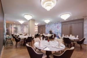 a dining room with tables and chairs and chandeliers at NARADA Resort Shanghai Hotel Disney Store in Shanghai