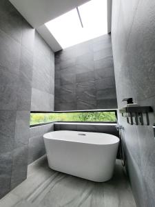 a white bath tub in a bathroom with a window at Poon Pool villa near Ruamchok Boxing private pool etc in Chiang Mai