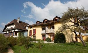 una casa grande en un campo con un árbol en EcoHotel L’Aubier, en Montézillon