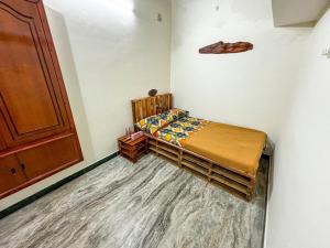 een slaapkamer met een bed met een houten bedframe bij Villa Seasoul in Pondicherry +1 foto