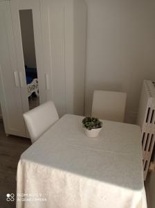 una mesa blanca con una maceta encima en Oasi di san Benedetto, en Castellaneta