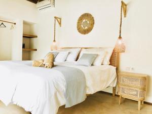 a bedroom with two beds with white sheets at AMAN Villas & SPA in Gili Islands