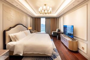 Postel nebo postele na pokoji v ubytování Jian Guo Hotel Yantai Phoenix Building + 37 fotografií