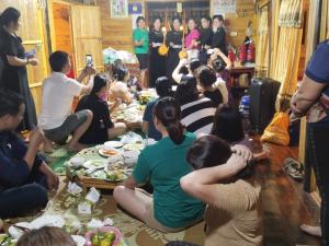 a group of people sitting around a table eating food at Triệu Chương Homestay in Dam Thuy