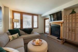 a living room with a couch and a fireplace at Premium Unit 2308 - 1Br - Zephyr Mountain Lodge condo in Winter Park +2 photos
