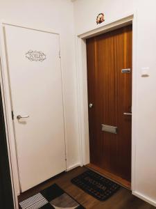 a hallway with a wooden door and a rug at Yyterin Kontu in Pori