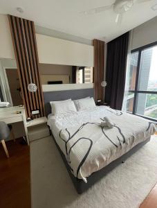 a bedroom with a bed with a desk and a window at Luxury Apt close to KLCC Aria in Kuala Lumpur