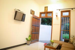 a living room with a couch and a tv at Kings Villa Mirissa in Mirissa