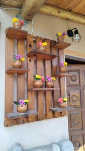 un mur avec des étagères en bois et des fleurs. dans l'établissement Cabañas Mónika III Norte, à Huerta Grande 38 autres photos
