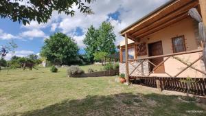 a farmhouse with a yard and a building at Cabañas Mónika III Norte in Huerta Grande