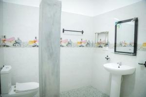 a bathroom with a sink and a toilet and a mirror at Kings Villa Mirissa in Mirissa +22 photos