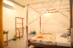a bedroom with a bed with a canopy and a ladder at Kings Villa Mirissa in Mirissa