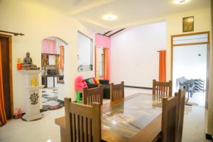 a living room with a glass table and chairs at Kings Villa Mirissa in Mirissa