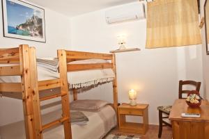 a bedroom with a bunk bed and a desk at B&B Villa Tancau in Santa Maria Navarrese