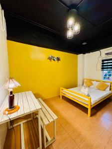 a yellow room with a bed and a table at Cheese Hostel Manila in Manila +30 photos