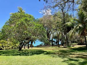 Villa exceptionnelle en bord de mer في ترو دو دوس: حديقة بها أشجار والمحيط في الخلفية