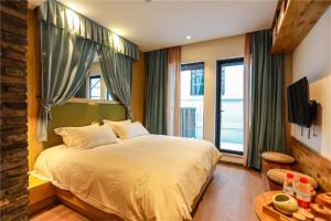 Tempat tidur dalam kamar di Huangliang Yimeng Designer Hotel Wuzhen Xizha Scenic Area Branch