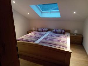 a bedroom with a large bed with a skylight at Deluexe Ferienwohnung Eckl in Prackenbach +12 photos