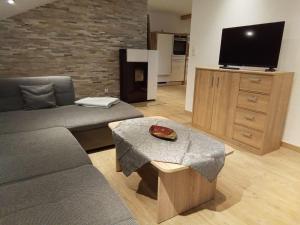 a living room with a couch and a tv at Deluexe Ferienwohnung Eckl in Prackenbach