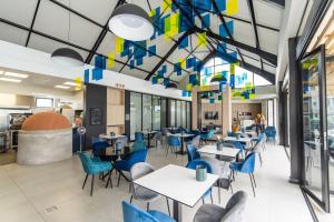 a dining room with blue chairs and tables at Just Beachy Bellamare Apartment in Summerstrand