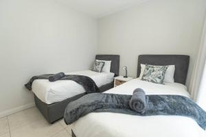 a room with two beds with blankets on them at Just Beachy Bellamare Apartment in Summerstrand +48 photos