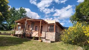 una pequeña casa con una pared de piedra en Cabañas Mónika IV Sur, en Huerta Grande