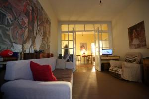 a living room with a white couch and a television at Cosy Hostel Tirana in Tirana