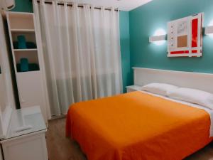 a bedroom with an orange bed and blue walls at Apartamentos Eldorado in Lloret de Mar