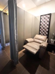 a waiting room with a chair in the corner at d'primahotel Airport Jakarta Terminal 1A in Tangerang