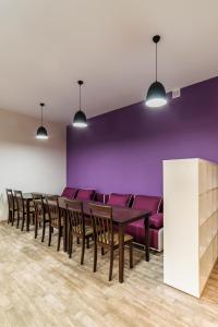een eetkamer met paarse muren en een tafel en stoelen bij Gar'is Hostel Lviv in Lviv