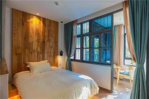 Ліжко або ліжка в номері Huangliang Yimeng Designer Hotel Wuzhen Xizha Scenic Area Branch