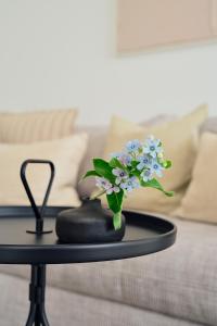 une table avec un vase de fleurs sur un canapé dans l'établissement Apartment B 6 "Pine Hill Resort", à Zirchow