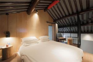 Ліжко або ліжка в номері Huangliang Yimeng Designer Hotel Wuzhen Xizha Scenic Area Branch
